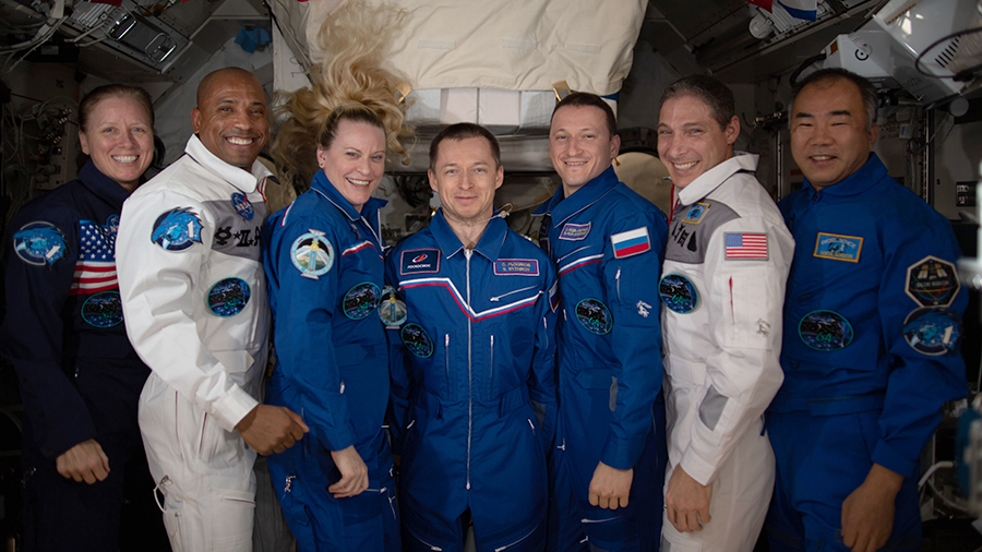 The seven-member Expedition 64 crew poses for a portrait inside the space station's Kibo laboratory module.