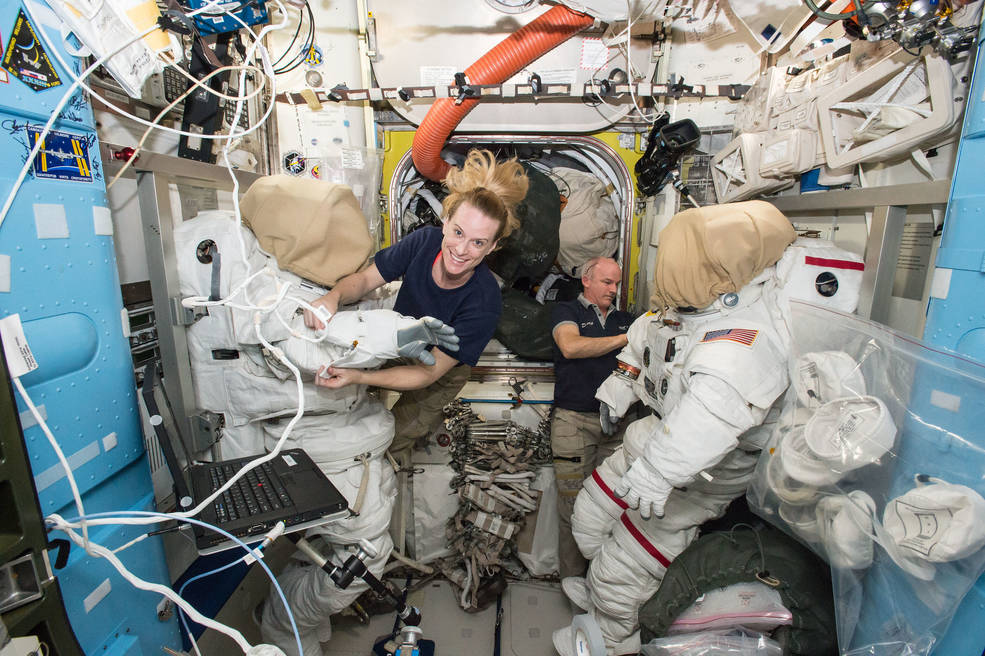 Expedition 48 crew members Kate Rubins (left) and Jeff Williams (right) of NASA outfit spacesuits inside of the Quest airlock