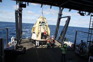 SpaceX's Crew Dragon is loaded onto the company's recovery ship, Go Searcher, in the Atlantic Ocean on March 8, 2019.