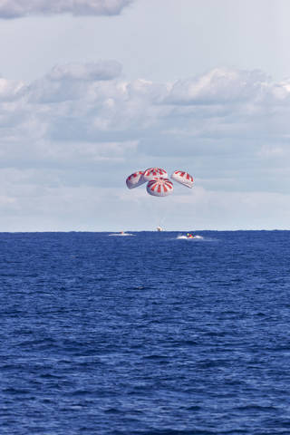 SpaceX's Crew Dragon is guided by four parachutes as it splashes down in the Atlantic Ocean on March 8, 2019