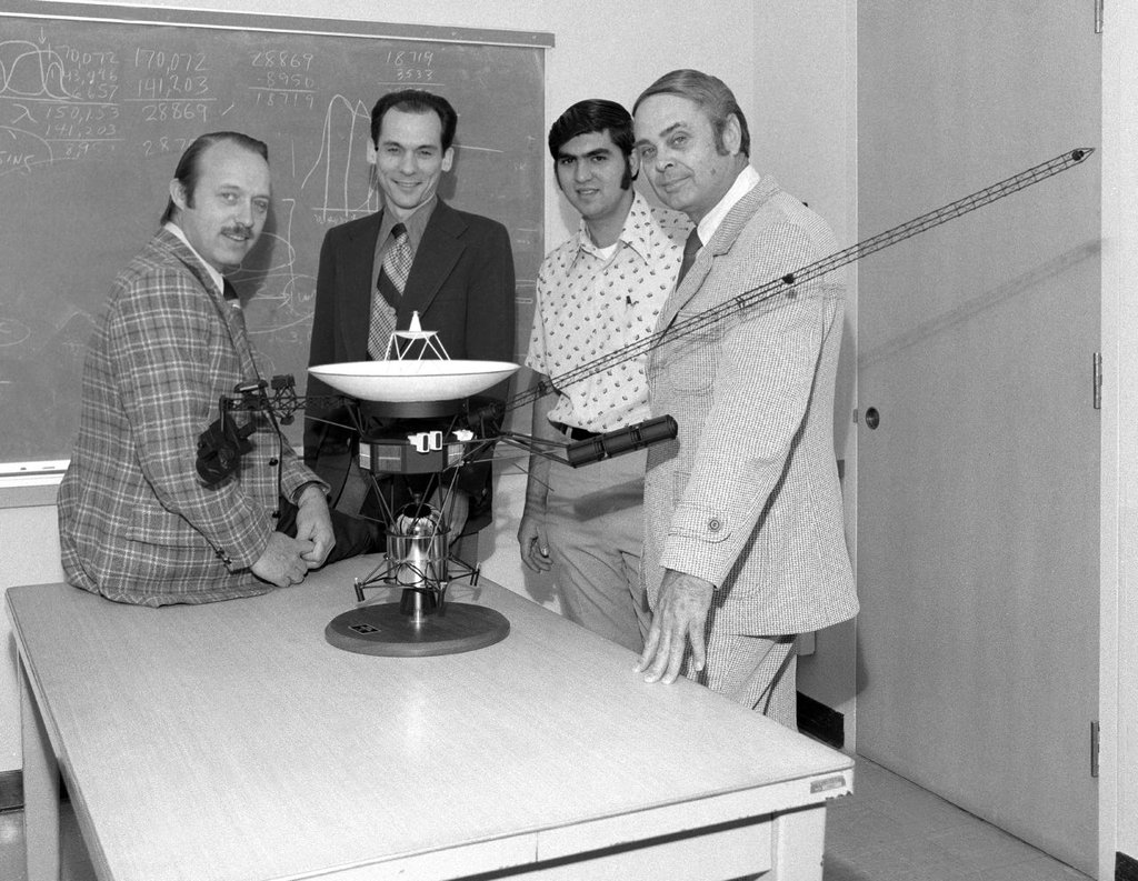 Ed stone, second from left, and othermembers of the Voyager team pose with a model of the spacecraft in 1977, the year the twin probes launched.