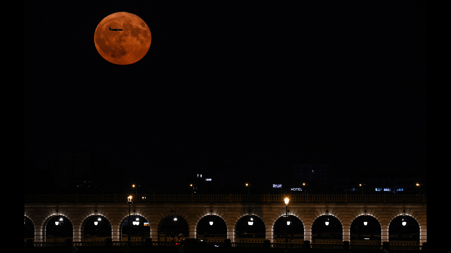Самолет пролетает на фоне Луны в Париже, Франция / © Stefano Rellandini / AFP / Getty Images