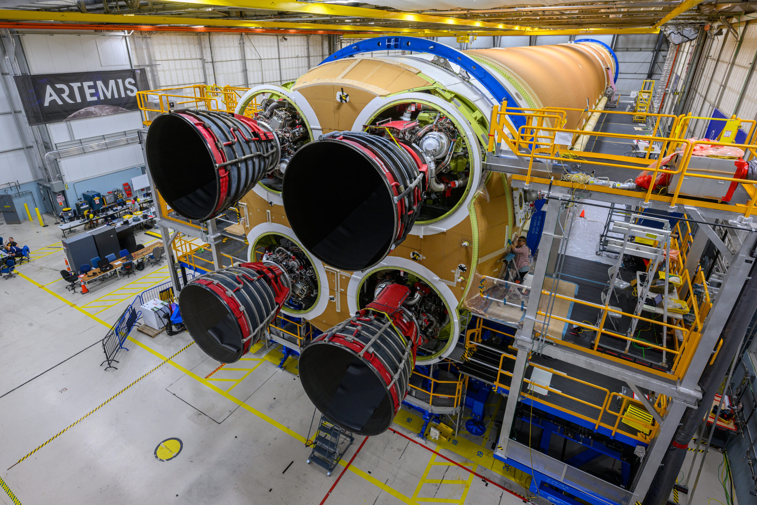 Engineers and technicians from NASA, Aerojet Rocketdyne, and Boeing at NASA's Michoud Assembly Facility in New Orleans have installed all four RS-25 engines to the core stage for NASA's Space Launch System rocket that will help power the first crewed Artemis mission to the Moon. The yellow core stage is seen in a horizontal position in the final assembly area at Michoud. The engines are arranged at the bottom of the rocket stage in a square pattern, like legs on a table.