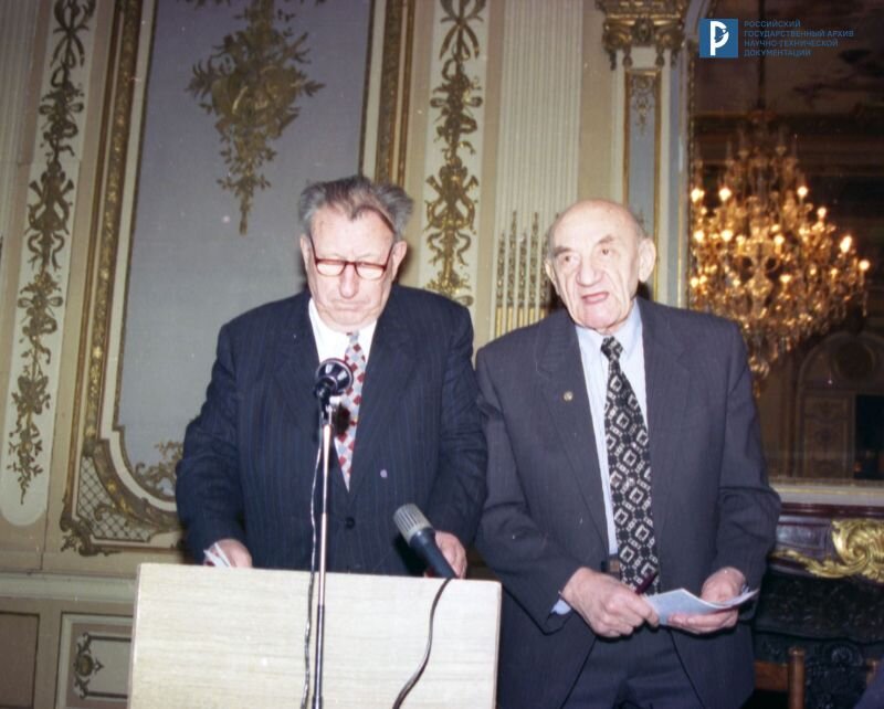 В.Ф. Уткин и Б.Е. Черток (слева направо) во время XXI научных чтений по космонавтике. 30 января 1997 г. РГАНТД. Арх. № 0-12426 цв. height=642px width=800px