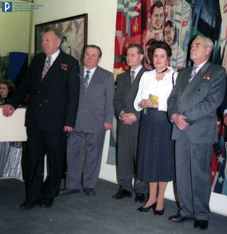 В.Ф. Уткин, П.Р. Попович, Н.С. Королева и А.Г. Николаев (слева направо) во время торжественного открытия выставки к 90-летию С.П. Королева. 21 января 1997 г. РГАНТД. Арх. № 0-13041 цв. height=800px width=775px