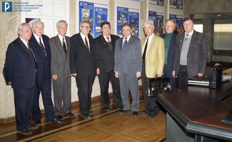 Н.С. Лидоренко, Б.В. Бальмонт, В.И. Севастьянов, В.Ф. Уткин (4-й слева), В.П. Сенкевич, Л.А. Гильдберг, Ю.В. Новиков, В.М. Вишняков, Б.Н. Кантемиров в фойе Академии космонавтики им. К.Э. Циолковского. 29 марта 1999 г. РГАНТД. Арх. № 0-14372 цв. height=490px width=800px