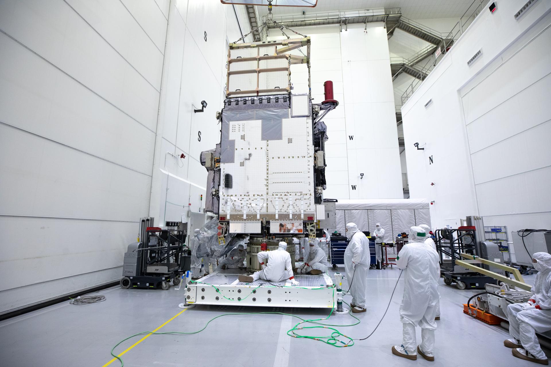 Technicians monitor movement and guide NOAA's Geostationary Operation Environmental Satellite-U (GOES-U) as a crane hoists it on to a spacecraft dolly in a high bay at the Astrotech Space Operations Facility near the agency's Kennedy Space Center in Florida.